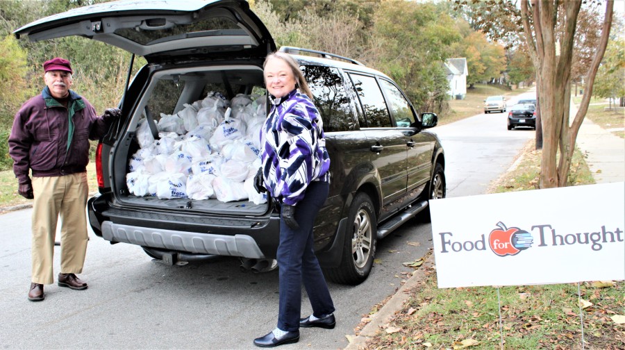 Gene Krueger and Kathleen Dunn load bags of food for delivery to Koontz Elementary.
